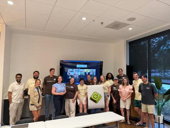 Teachers and developers gathered together with virtual attendees joining onscreen
